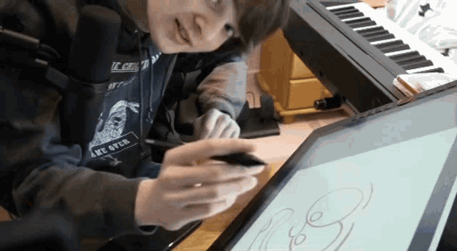 a person wearing a hoodie that says " take over " is drawing on a tablet