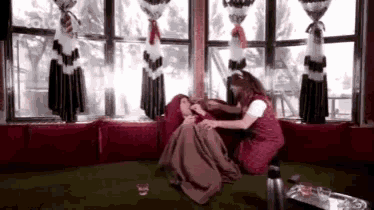 a woman is sitting on a couch with a blanket on a woman .
