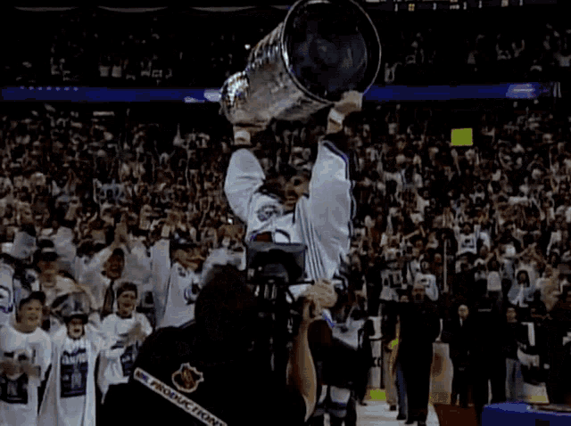 a hockey player with the number 7 on his jersey holds a trophy