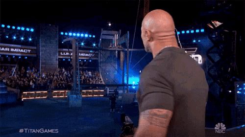 a man is standing in front of a crowd with the hashtag #titangames