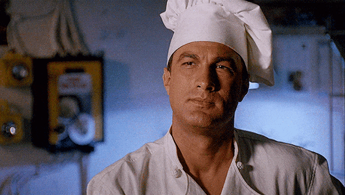a man wearing a chef 's hat and a chef 's jacket