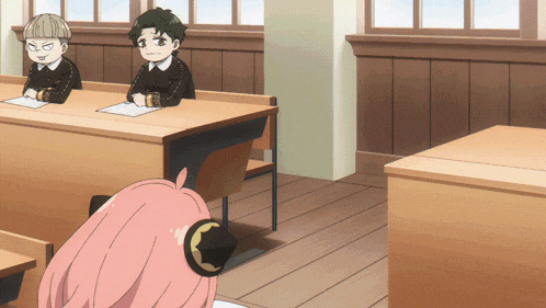 a girl with pink hair is sitting in a classroom with other children