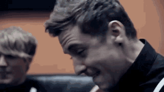 a close up of a man making a funny face while sitting on a couch .