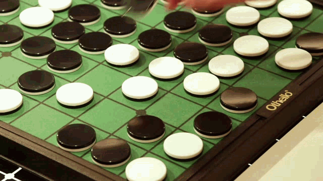 a person is playing a game of othello on a table