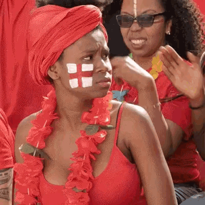 a woman with a flag painted on her face is wearing a red shirt