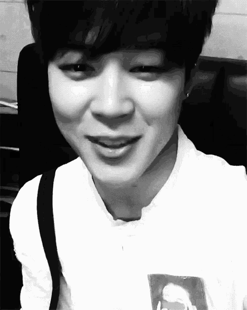a black and white photo of a young man smiling