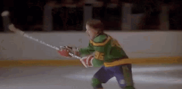 a young boy is playing ice hockey on the ice .