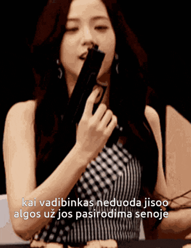 a woman holding a gun with the words kai vadibinkas neduoda jisoo algos uz jos pasirodima senoje in the corner