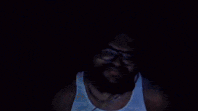 a man with glasses and a mustache giving the peace sign