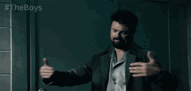 a man with a beard is standing with his arms outstretched in front of a brick wall .