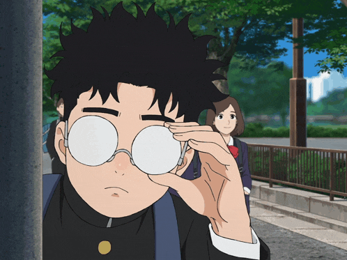 a boy wearing glasses is looking through a hole in a pole