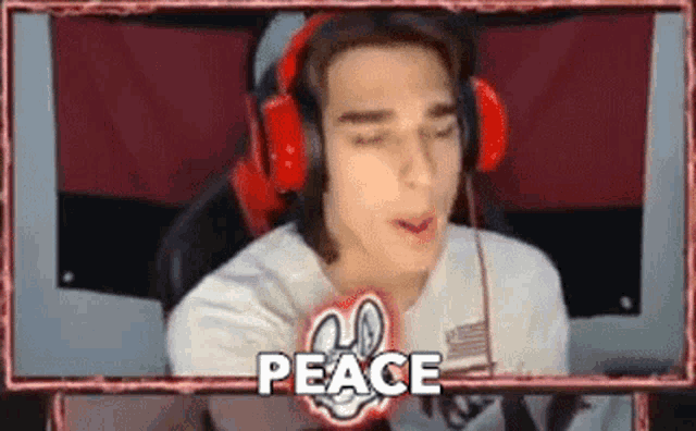 a young man wearing headphones is sitting in front of a computer screen with the word peace written on it .