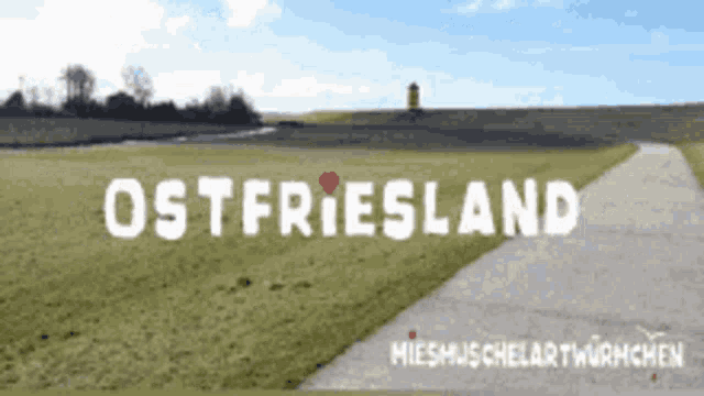 a sign that says ostfriesland with a path in the foreground