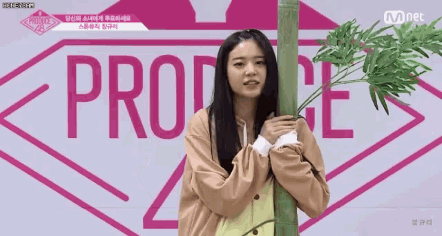a girl is hugging a tree in front of a mnet logo .