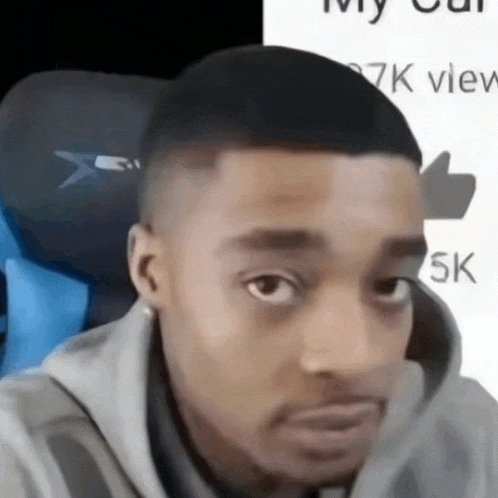 a close up of a man 's face with a thumbs up in the background
