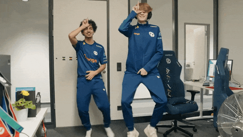a man in a kappa shirt is dancing with another man in a blue suit