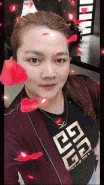 a woman wearing a black shirt with a gold givenchy logo on it