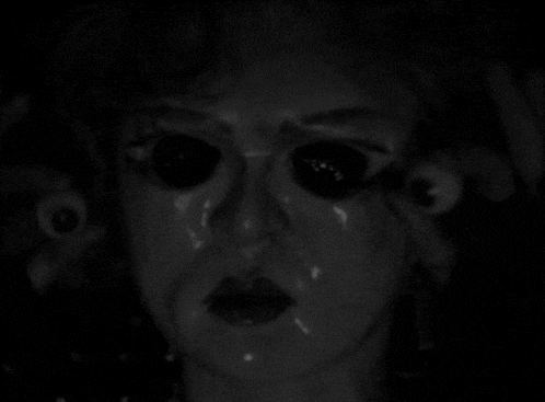 a black and white photo of a doll 's face with big eyes