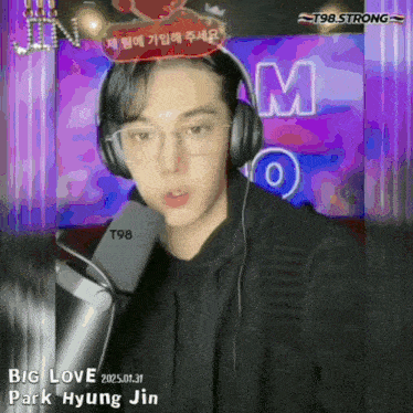 park hyung jin is wearing headphones and glasses while talking into a microphone