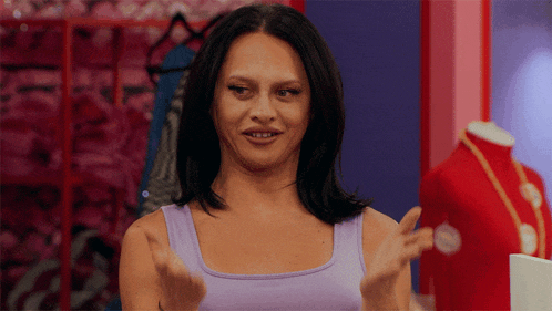 a woman wearing a purple tank top making a funny face