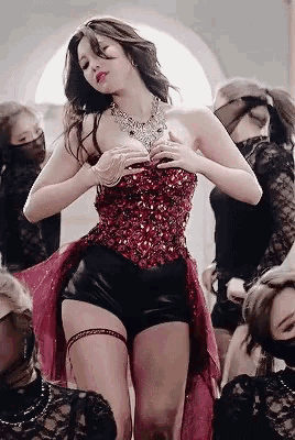 a woman wearing a corset and a necklace is surrounded by other women