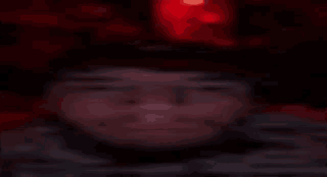 a blurry picture of a person 's face with a red light behind them .