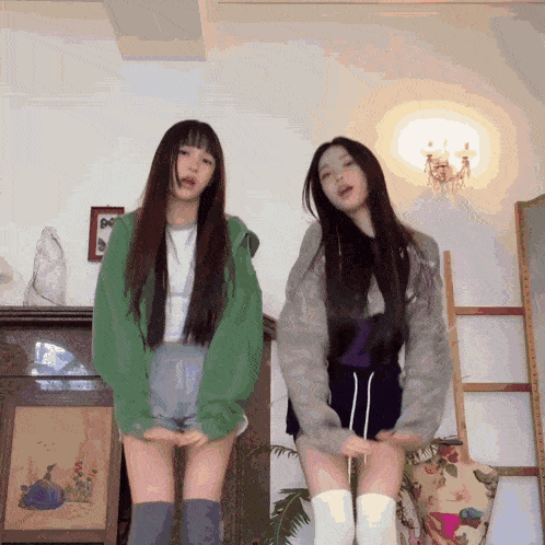 two girls are standing next to each other in a room