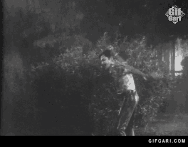 a black and white photo of a man dancing with a gifgari.com logo in the corner