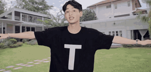 a man wearing a black shirt with a white letter t on it