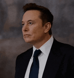 a man in a suit and tie looks to his left