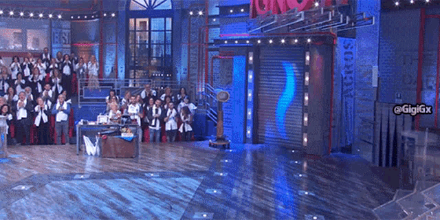 a group of people standing in front of a stage with a sign that says gigigx