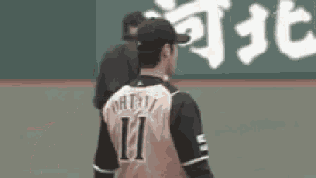 a baseball player wearing a number 11 jersey is standing on the field .