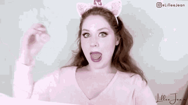 a woman wearing a headband with bunny ears is taking a picture of herself .