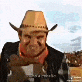 a man in a cowboy hat and scarf is holding a horse .
