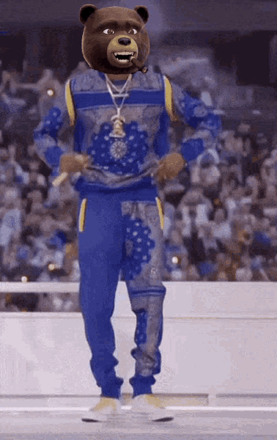 a man with a teddy bear head is wearing a blue sweater