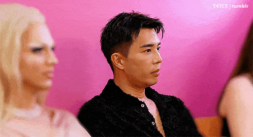 a man and a woman are sitting next to each other on a pink background .
