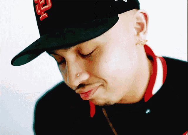 a man wearing a black hat with a red letter f on it