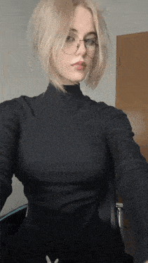 a blonde woman wearing glasses and a black turtleneck sweater