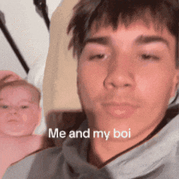 a man is holding a baby with the words me and my boi on his face