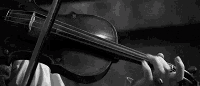 a woman is playing a violin in a black and white photo .