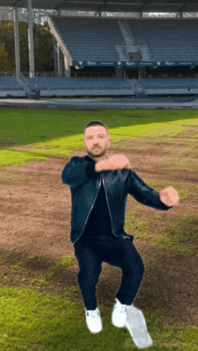 a man in a blue jacket is dancing on a field