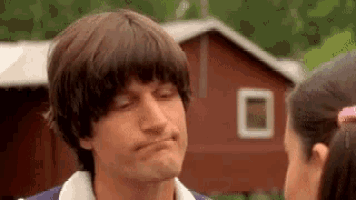 a man is making a funny face while looking at a girl .