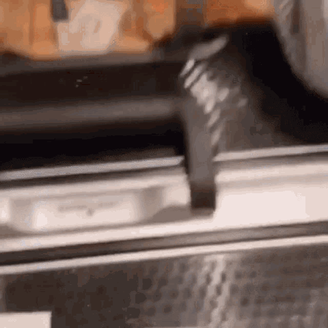 a close up of a stainless steel dishwasher with a sliding door .