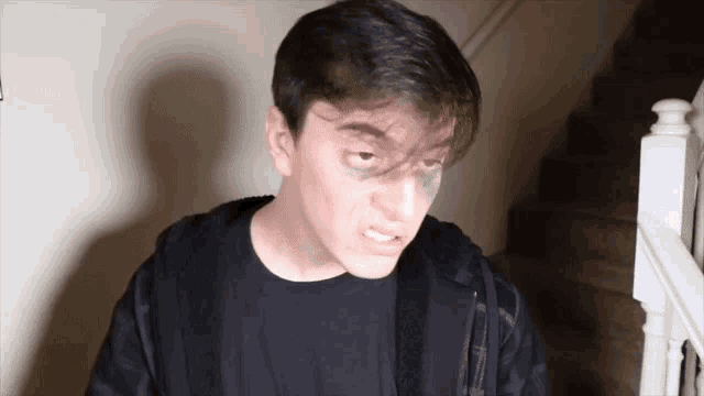 a young man with a black eye is standing in front of a set of stairs