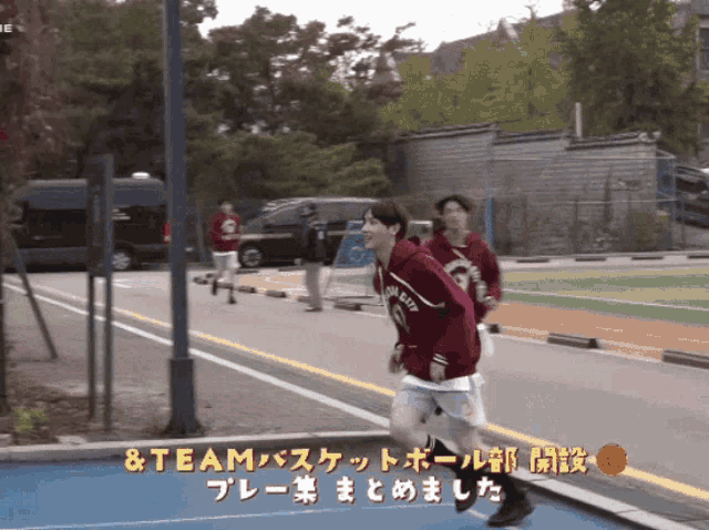 a man in a red hoodie with the word team on it is running down a street