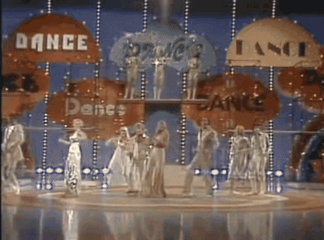 a group of people dancing on a stage with a sign that says dance