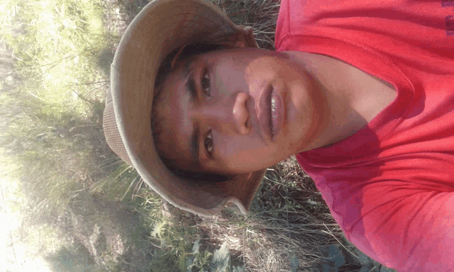 a young man wearing a hat and a red shirt with the word columbia on it