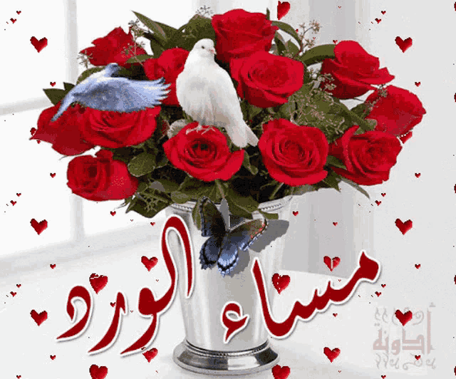 a bouquet of red roses in a silver vase with a white bird on top