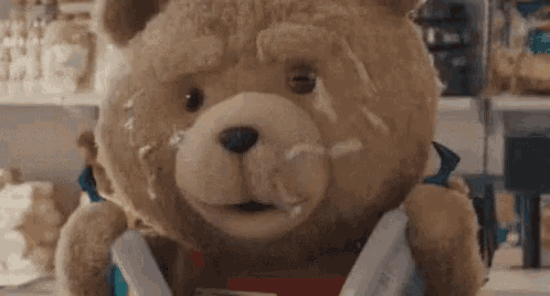a close up of a teddy bear with a lot of food on it 's face .