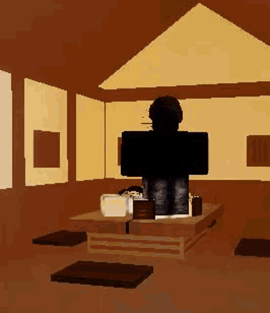 a person is sitting at a table in a room with a laptop .